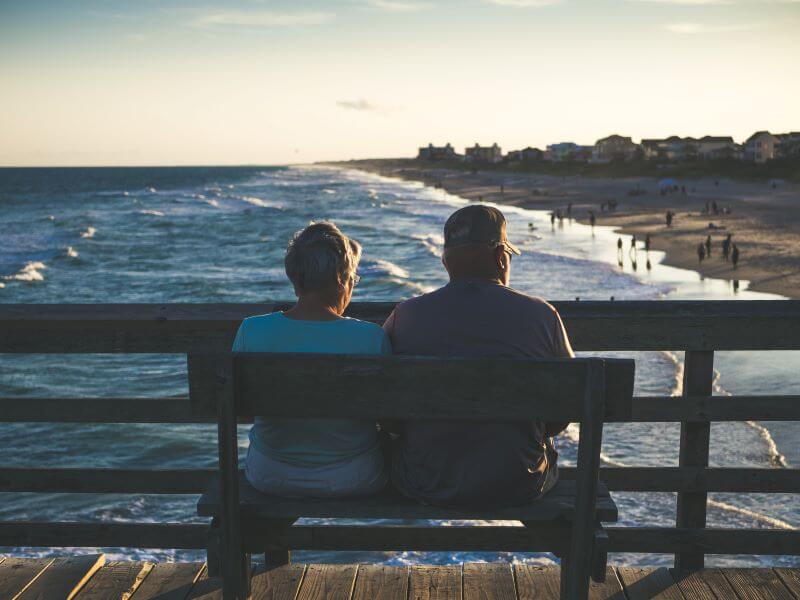 Couple sitting on bench at beach